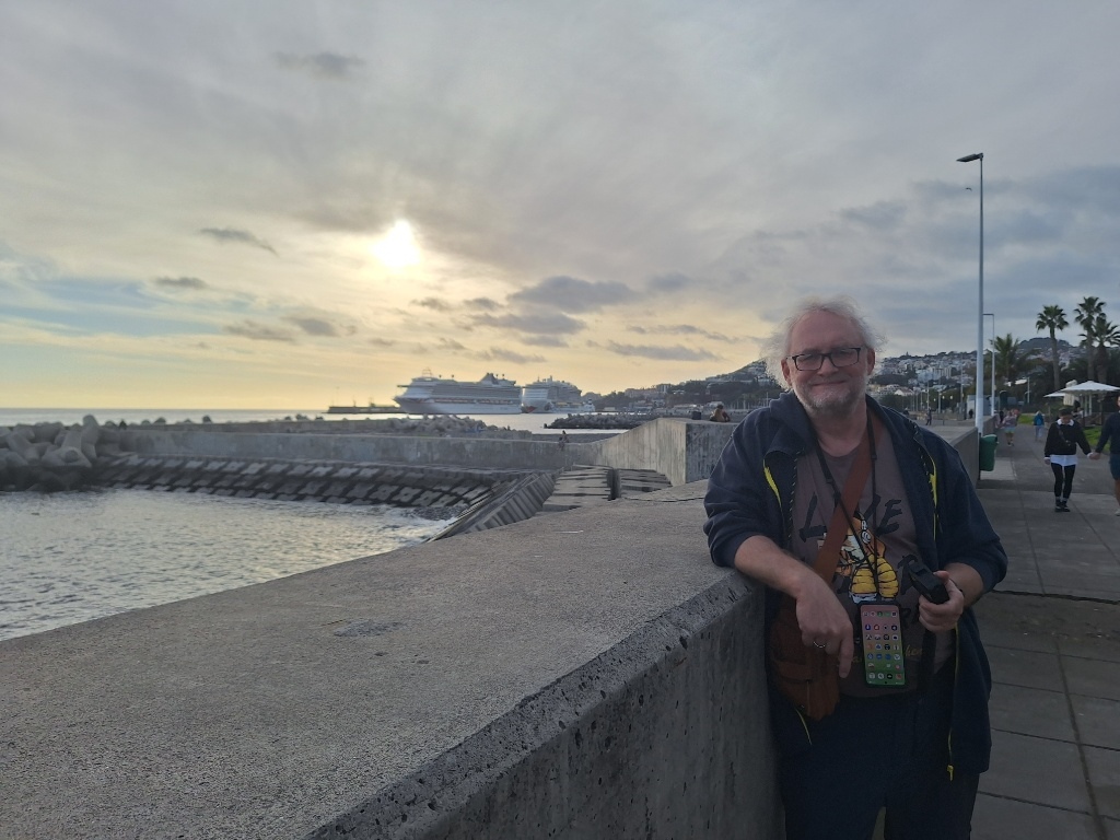 Mann am Pier vor Kreuzfahrtschiffen